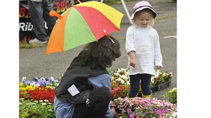 Swissvale's Camille Miller, 2, points to flowers that she likes with her nanny, Christine Capriotti, at opening day of the East Liberty Citiparks Farmers Market. Citiparks runs seven markets around Pittsburgh.