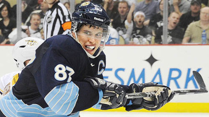 Pittsburgh Penguins captain Sidney Crosby battles for a  loose puck against the Predators.