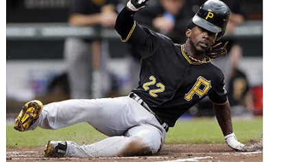 The Pirates' Andrew McCutchen loses his helmet as he slides into home plate for a run on a single by Matt Hague in the first inning.