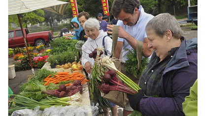 Shoppers at the Harvest Valley Farms stand at the East Liberty market.