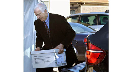 Jerry Sandusky helps unload case files from his attorney's car as he arrives at the Centre County Courthouse for the third day of his trial.