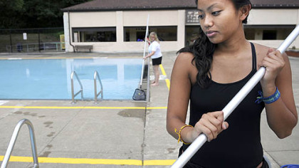 Lifeguards Sarah Tajuddin, 19, right, and Theresa Guzik, 21, clean the pools at Highland Park on Monday.