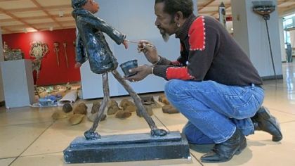 Self-taught artist Gregory Warmack, aka Mr. Imagination,  does some last minute touch-up on "Taking a Walk" at the Society for Contemporary Craft in the Strip District in 2002. The artist died May 30.