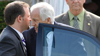 Jerry Sandusky whispers to his attorney Karl Rominger as he leaves the Centre County Courthouse after the second day of testimony in his trial. At right is Centre County Sheriff Denny Nau.