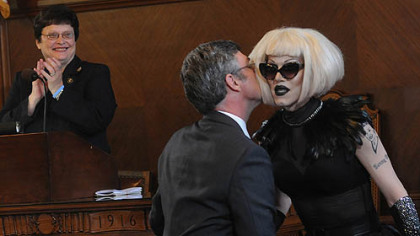 After reading a proclamation in City Council honoring drag queen Sharon Needles, right, Councilman Patrick Dowd gives her a kiss as Council President Darlene Harris reacts in the background. Ms. Needles is the most recent winner of "RuPaul's Drag Race," a television competition.