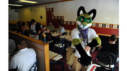 A man who wished to be identified only by his character's name, Danger Fox, puts on his costume's gloves after eating at Fernando's Cafe.