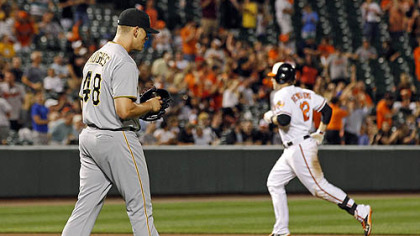 Pirates relief pitcher Jared Hughes, left, walks to the mound as Orioles' Mark Reynolds rounds the bases after hitting a solo home run in the eighth inning.