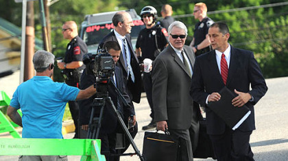 The prosecutor in the Sandusky case, Joseph E. McGettigan III, center, outside the Centre County Courthouse.