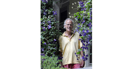 Basil Cox framed by clematis on his back porch.