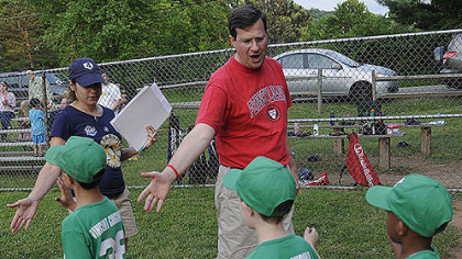 Neil Alexander, an assistant coach for his son's Little League baseball team, shakes hands with children from the opposing team after a game in Fox Chapel on May 22.