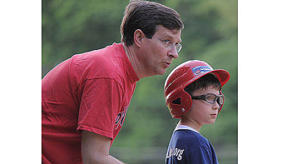 Neil Alexander gives coaching advice to his son, Patrick, who was given number 4, the same number Lou Gehrig wore for the New York Yankees.
