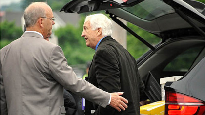 Centre County Sheriff Denny Nau, left, helps Jerry Sandusky as he enters the Centre County Courthouse on Monday for the fifth day of testimony in his trial.