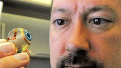 Shawn Kelly with a model of the artificial retina.