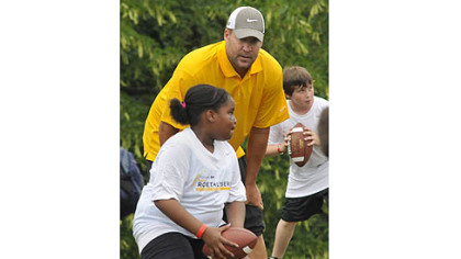 Steelers quarterback Ben Roethlisberger gives instruction in passing to youths during workouts at his football camp at Seneca Valley High School.