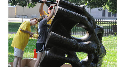 From left, Marie Vilello, Sara Stringellow and Steve Stevenson, all of Lock Haven, Pa., assemble parts of a climbing wall for the new KaBOOM! playground.