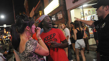 A Pittsburgh police officer tells the crowd to keep moving early Sunday morning along East Carson Street.