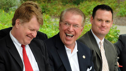 John Bonassi, board chairman of the EQT Pittsburgh Three Rivers Regatta,  laughs at comments made by emcee Larry Richert during the press conference at Point State Park.  To the left is Allegheny County Executive Rich Fitzgerald, and to the right is Pittsburgh Mayor Luke Ravenstahl.