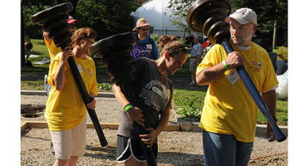 PLCM President Richard P. Vilello Jr., mayor of Lock Haven, leads the way carrying playground parts.