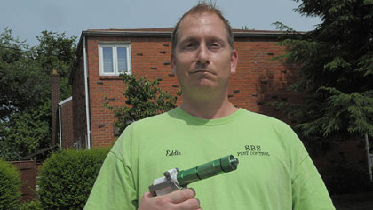 Edward McCoy, who runs Stink Bug Specialist, stands outside a home in Stanton Heights that he treated for stink bugs.