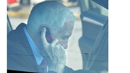 Jerry Sandusky talks on his phone inside the car as he arrives at the Centre County Courthouse for the seventh day of testimony in his trial Wednesday morning.