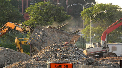 Dust spews from the remaining part of the cantilever of the Civic Arena Monday, as demolition continues. A parking lot is slated to open on the site at the end of July.