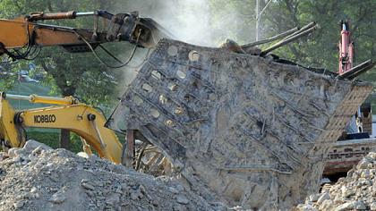 Dust spews from one of the few remaining parts of the Civic Arena Monday, as demolition continues. A parking lot is slated to open on the site at the end of July.