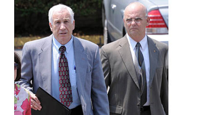 Jerry Sandusky leaves the Centre County Courthouse after the jury began deliberating his case. At right is Centre County Sheriff Denny Nau.