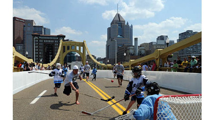 NHL draft  prospect Nail Yakupov of Russia, left, chases down a ball while playing street hockey with local kids from the Pittsburgh Ice inner city program at a specially-built dek hockey rink on the Clemente Bridge.
