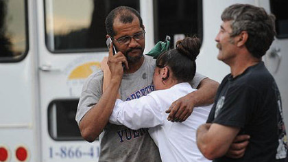 James Gatewood, left, hugging his daughter Jamie Gatewood, and Charles Kraus, all of Duquesne, stand outside Meade Brother's Trucking where a fatal shooting occurred in McKeesport today.