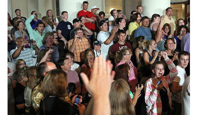 People gathered on the front steps of the courthouse cheer when they learn of the verdict.