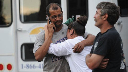 James Gatewood, left, hugs his daughter, Jamie Gatewood, as Charles Kraus, all of Duquesne, walks by outside Meade Brothers' Trucking in McKeesport, where a fatal shooting occurred Friday. Mr. Gatewood and Mr. Kraus both worked for the company.
