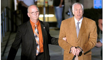 Jerry Sandusky is led in handcuffs by Centre County Sheriff Denny Nau after being found guilty Friday night on 45 counts of sexual abuse at the Centre County Courthouse in Bellefonte.
