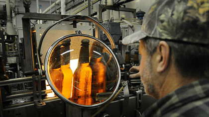 Bottle house supervisor Dave Weinzierl inspects beer for imperfections at Straub Brewery.