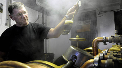 Brewmaster Raymond "Goona" Frank checks for impurities in the beer.
