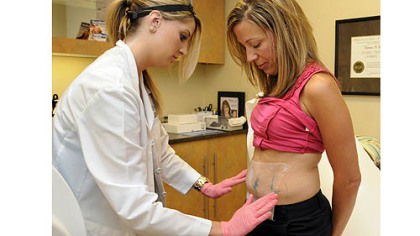 Kasey Chester, left, an aesthetician at the Skin Center in Shadyside, places a skin protection sheet on Melanie Driscoll of Mt. Lebanon
