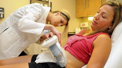 Kasey Chester, left, has the CoolSculpting machine applied to her abdomen.