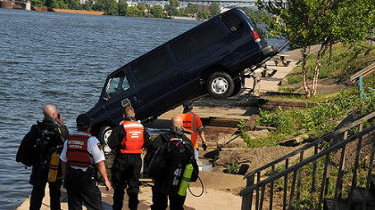 Members of the City of Pittsburgh's River Rescue team watch as the crew from McGann and Chester Towing pull the van from the Ohio River.
