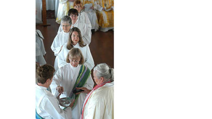 Eileen McCafferty DiFranco of Mount Airy pours water into a bowl in a "Mingling of Waters" ceremony during ordination of women deacons and priests by the Roman Catholic Womenpriests Community in Pittsburgh in 2006.