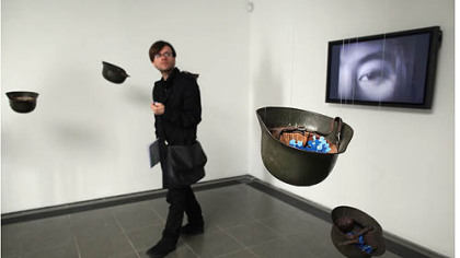 A reporter walks through a piece of work titled "Helmets" by Yoko Ono at the Serpentine Gallery in London.