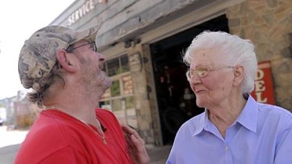 Dorothy Genser jokes with Tom Ganster on June 19 outside the gas station that has been in her husband's family since 1928. Ms. Genser, who still works at the station, started at the gas station more than 70 years ago when her husband, Clarence, went to fight in World War II. She said she remembers a quieter time at the gas station. "When you get old you like it to be quiet," she said. "It's like a race now. People speed."