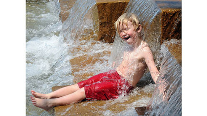 Julian Macdonald, 5, cools off in the water feature on Pittsburgh's North Shore today.