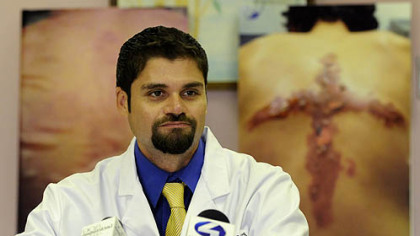 Dr. Ariel Aballay, director of West Penn Burn Center,  in front of photos of the injuries a 12 year-old boy received by placing salt and ice on his back.