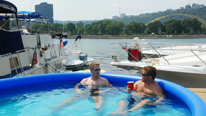 Jeff Wetzel, of Shaler, and Jon Mosimann, of Neville Island, spend their Friday in a pool on the North Shore. Both docked their boats in preparation for the Kenny Chesney concert this weekend.