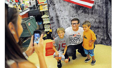 Coleman Scott of Waynesburg poses with Ayden Pratt, 9, left, and Brody Pratt, 2, as their mother Kelli Pratt takes a photo Friday at a Giant Eagle in Rices Landing. Mr. Scott will be wrestling in the 2012 London Olympics next month.