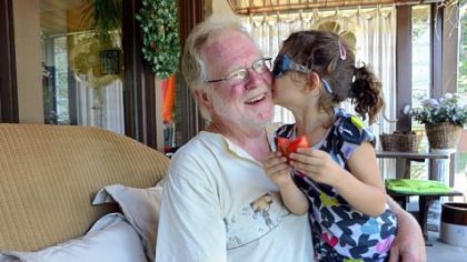David Taiclet and his granddaughter Ava Hogan, 5, enjoy time together as she has her first garden tomato of the day.