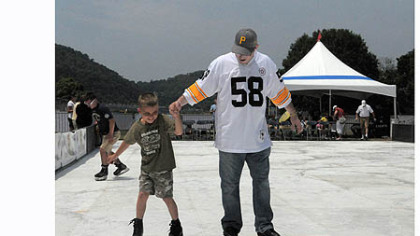 Jared Bellan of Monaca and his son Jayden Bellan, 7, try out the "Point SKATE Park", an artificial ice rink set up at the 2012 EQT Pittsburgh Three Rivers Regatta at Point State Park.