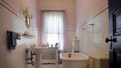 The original bathroom on the second floor has a clawfoot tub, hexagonal and subway tile and a porcelain pedestal sink.