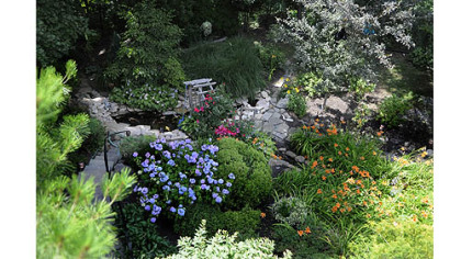 Paths wind around the koi pond, seen from the deck. The arbor also is visible.