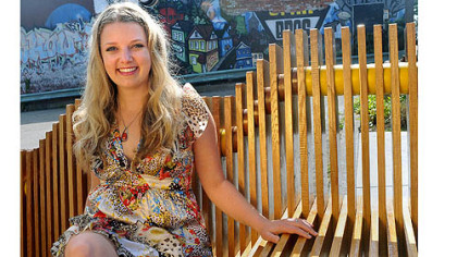 Kate Stoltzfus, founder of the blog Yinzpiration, sits on a new bench installed on Penn Avenue in Garfield.