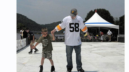 Jared Bellan of Monaca and his son Jayden, 7, try out the "Point SKATE Park", an artificial ice rink set up at the 2012 EQT Pittsburgh Three Rivers Regatta at Point State Park on Saturday.